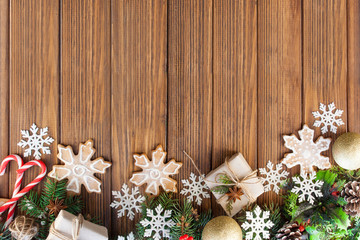 Obraz na płótnie Canvas Christmas gifts, Christmas decorations, Christmas cookies, tree branches and snowflakes on a wooden background. Flat lay style