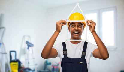 profession, building and repair concept - happy smiling indian repairman or builder in helmet with...