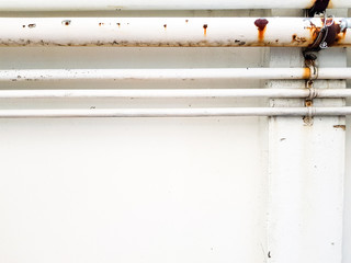 rust white water supply pipe hang with white wall outside of the industrial building. with rusty effect and corroded part from many year of used with copy space area for text.