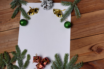 Christmas decorations on a white background table with a blank white sheet. New Year's pine cones and New Year's balls. Place for text
