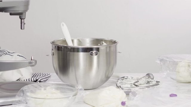Step by step. Mixing ingredients in standing kitchen mixer to make buttercream frosting.