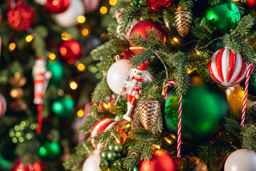 Christmas background tree branch with decorations candy lollipop cane red and green balls, with...