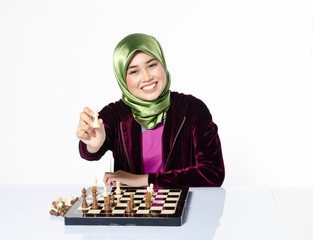 active young woman playing chess over white background