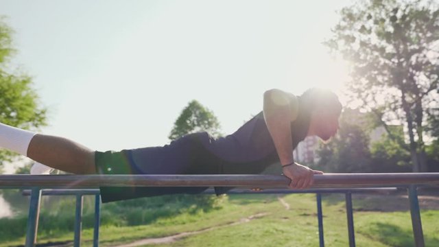 Fit young afro american man doing push ups on parallel bar