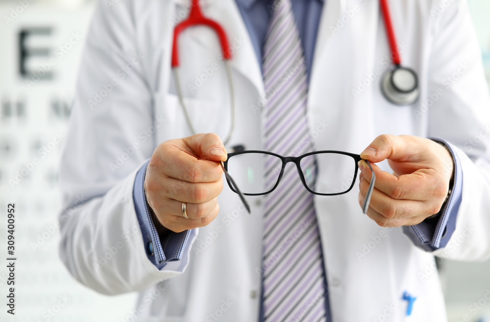 Wall mural male medicine doctor hands giving pair of black glasses