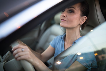 Pretty, young woman  driving a car -Invitation to travel. Car rental or vacation.