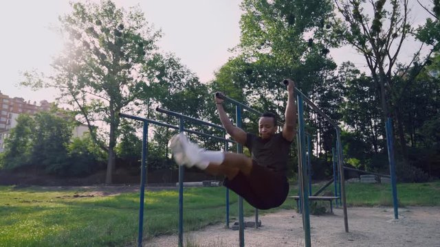 Afro american active man doing abs workout at park