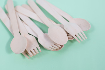 Brown wooden spoons and forks -cutlery lie on a green nature background. The concept of...