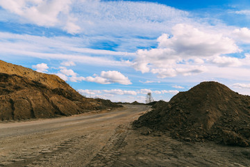 Road in stone quarry. Descent into the stone quarry. The road to the bottom of the quarry. Dusty winding road