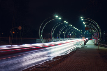 Fototapeta na wymiar Cars driving over a bridge in night time
