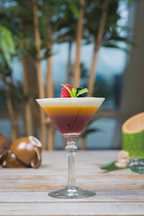 Tiramisu traditional dessert in a glass goblet on a wooden table.