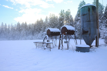 Winter old American Country landscape with rustic houses, cars and fences covered in snow.