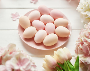 Spring and Easter holiday greeting card concept. Pink and white hydrangeas, yellow tulips with pink eggs. Colorful easter eggs and branch with flowers. Postcard Template. Copy space. Flat lay.