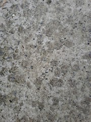  close-up of a decorative wall made of concrete, with a characteristic rough porous texture, abstract dark and light stains