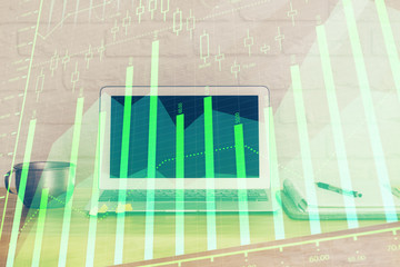 Stock market chart hologram drawn on personal computer background. Double exposure. Concept of...
