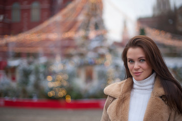 brown-haired girl on the background of Christmas lights