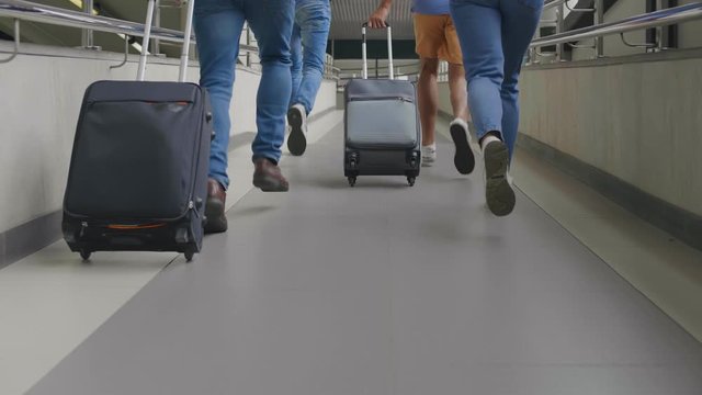 Group of tourists running in airport being late for plane.