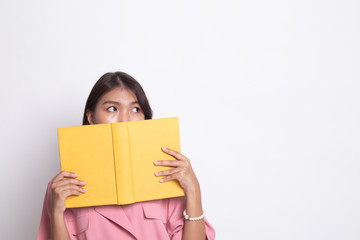 Obraz premium Young Asian woman with a book cover her face.