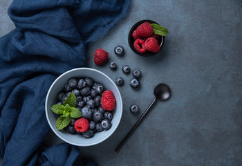 Fresh and sweet blueberry and raspberry in bowl with classic blue napkin  on dark blue wood...
