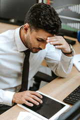 high angle view of pensive bi-racial trader using digital tablet