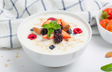 Yogurt with granola, fresh strawberries, raspberry, blueberries, blackberries, almonds and mint. Healthy snack. Breakfast food. 