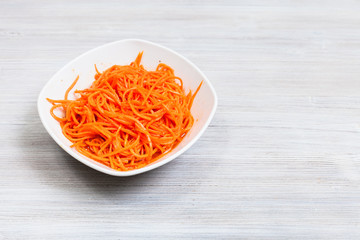 Koryo-saram spicy carrots in bowl on gray table