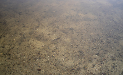 Background of a riverbed through the surface of the water