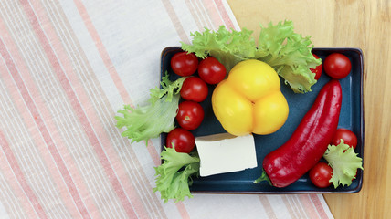 Nutritious components ideal for an appetizing fresh vegetable salad on a wooden board.