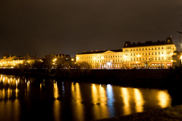 Fototapeta na wymiar Night city landscape and panorama in the bright evening lights of the Czech capital Prague overlooking the Vltava River.