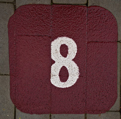 Painted 8 eight  on a pavement bourgundy background