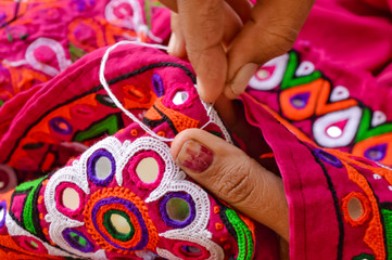 female needlework on fabric material close up view,Unidentified Tribal women sewing ethnic...