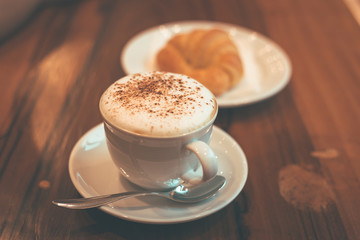 The cup of coffee is on the table in the coffee shop.