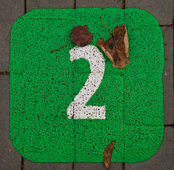 Painted 2 two on a pavement green background