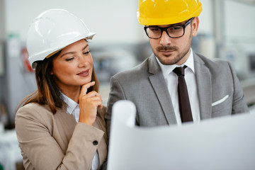 Close up of colleagues in factory. Architects working on project.