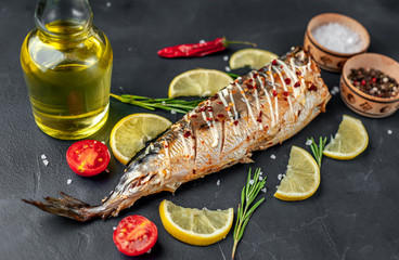 baked mackerel with lemon and spices on a stone background, ready to eat