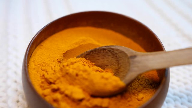 Turmeric Powder In Wooden Bowl. Close-Up.