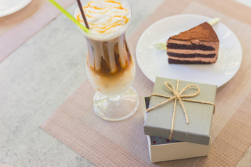 open empty gift box near Cake on dish and milk tea.they are on table.  A present on holiday.
