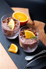 Healthy food concept Chia chocolate orange pudding with granola and pumpkins seed topping in the glasses