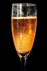 One glass of glittering champagne on black background. Sparkles in beverage on black background. Happy New Year.