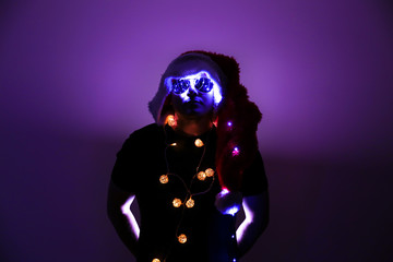 New year photo. Man in Santa hat with Christmas lights. Stylish holiday postcard.