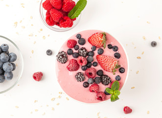 Smoothie bowl with yogurt, muesli and frozen berry. Pink yogurt smoothie bowl topped with frozen...