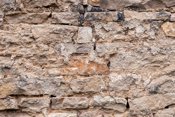 Textural background. Closeup brick stone old aged ancient brown wall