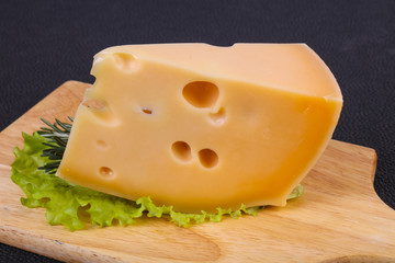 Maasdam cheese  in the board served salad leaves