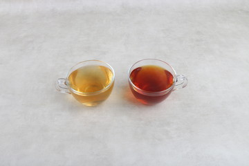 green Tea and red tea Cups on a white texture background - white table