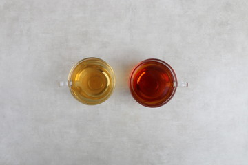 green Tea and red tea Cups on a white texture background - white table