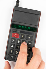 Count with your fingers on the buttons of the old Soviet calculator with luminous green LEDs numbers on a white background, view from the top