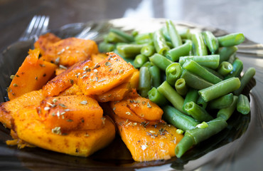 Warm salad with roasted pumpkin,  green beans,oregano and spices. Healthy vegetarian nourishment. Low fat healthy eating concept