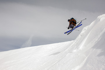Fototapeta na wymiar Skier takes off the ground while sliding down