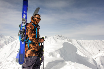 Man with ski and other equipment stands