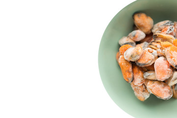 Mockup frozen mussel seafood in a green bowl on a isolate white background free space for text banner. Healthy food offal ingredients. Close-up top view.